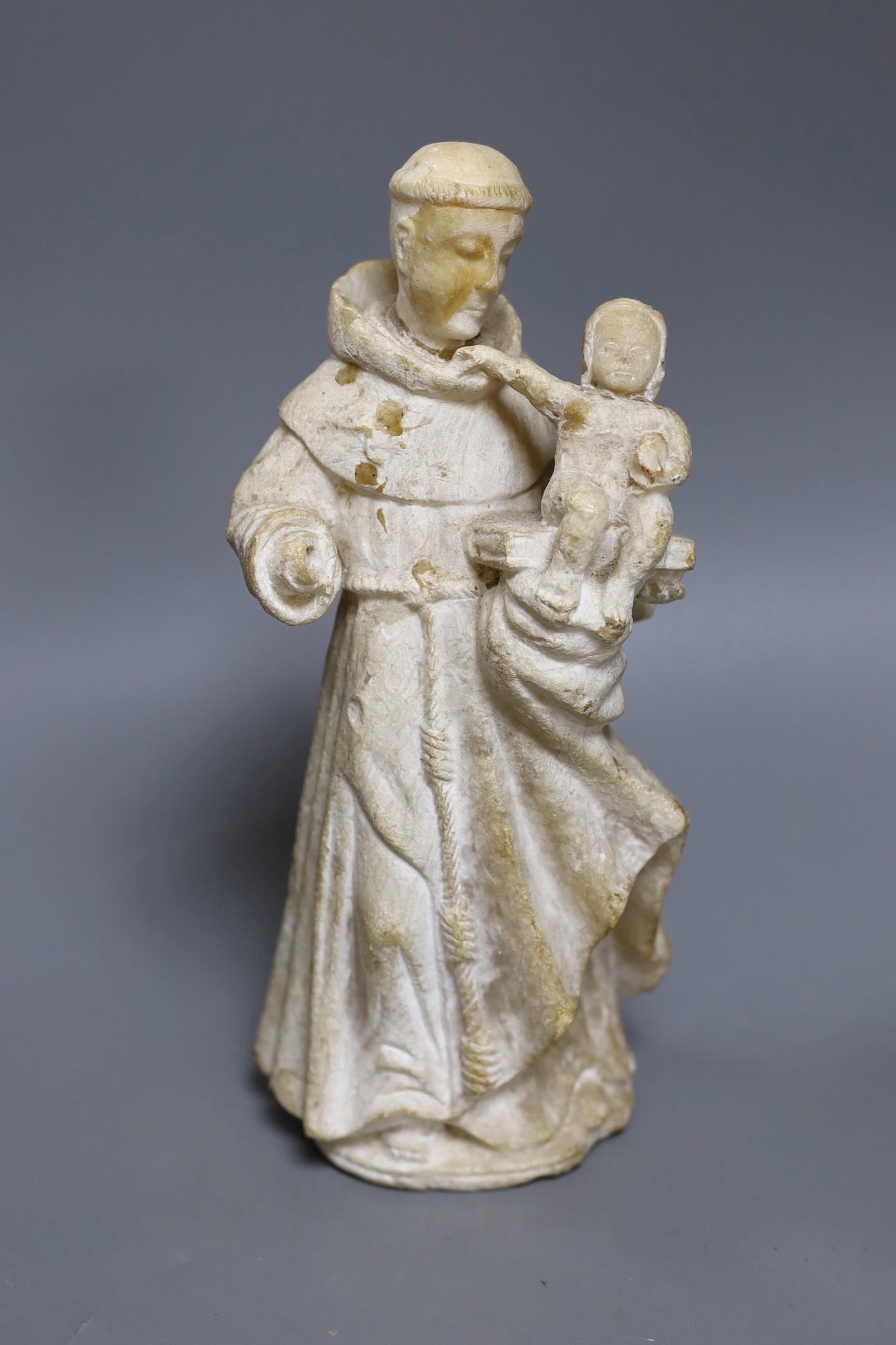 A 19th century carved alabaster group, friar with child 28cm